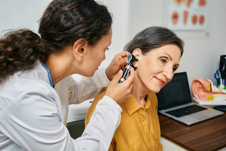 Professional audiologist conducting hearing examination